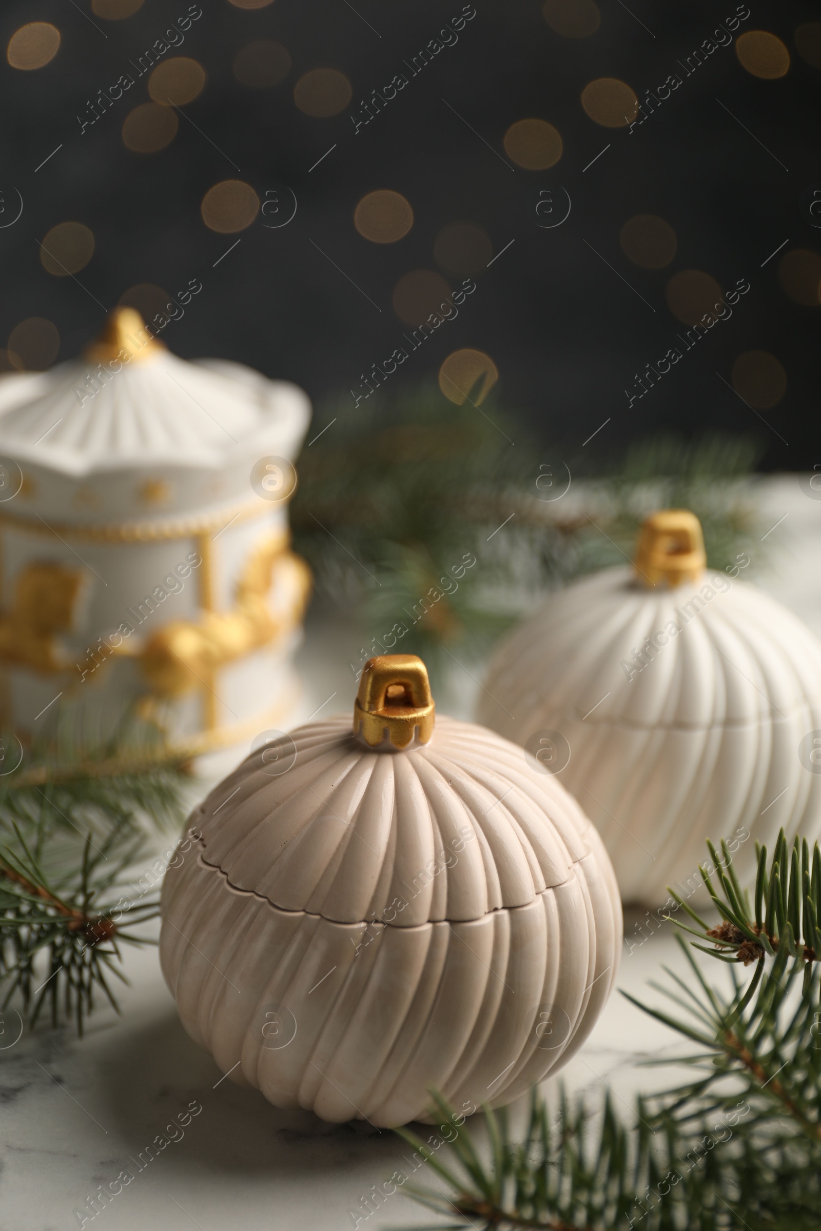 Photo of Soy wax candles and green fir branches on white table, closeup. Beautiful Christmas decor