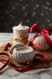 Photo of Soy wax candles on white marble table, closeup. Beautiful Christmas decor