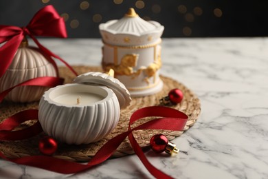 Photo of Soy wax candles on white marble table, closeup and space for text. Beautiful Christmas decor