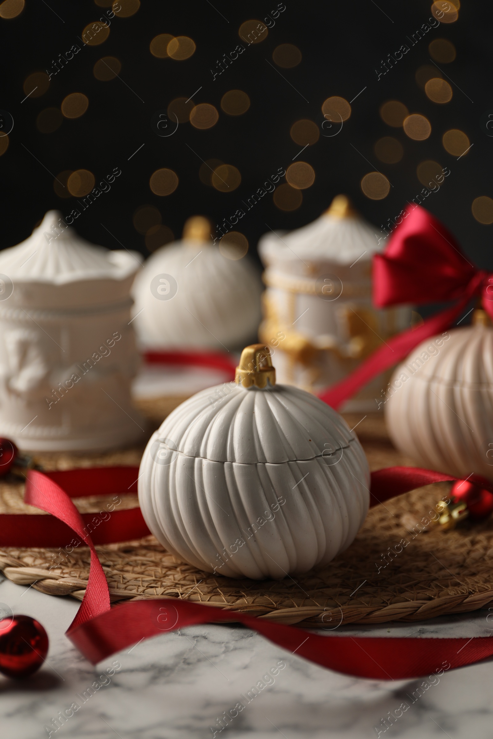 Photo of Soy wax candles on white marble table, closeup. Beautiful Christmas decor