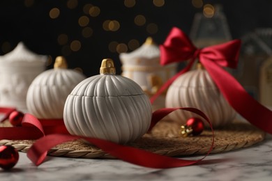 Photo of Soy wax candles on white marble table, closeup. Beautiful Christmas decor