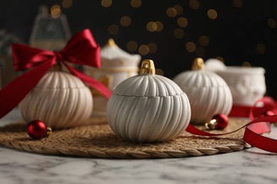 Photo of Soy wax candles on white marble table, closeup. Beautiful Christmas decor