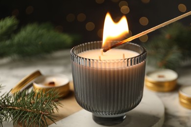 Photo of Lighting soy candle at white table, closeup