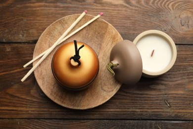 Photo of Soy candles and matches on wooden table, flat lay