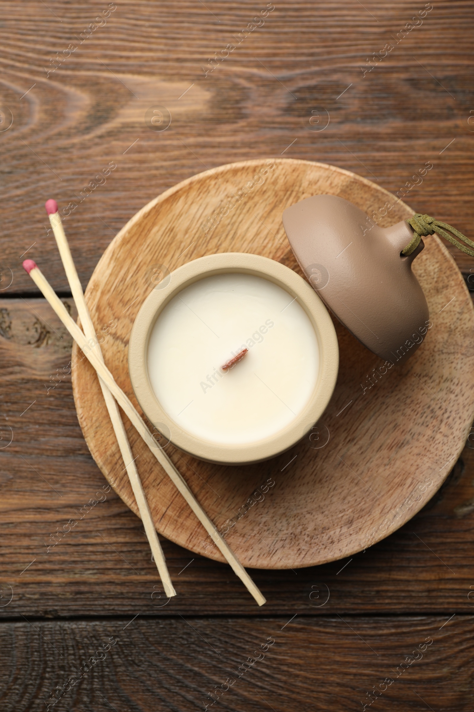 Photo of Soy candle and matches on wooden table, top view