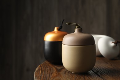 Photo of Different soy candles on wooden table, space for text