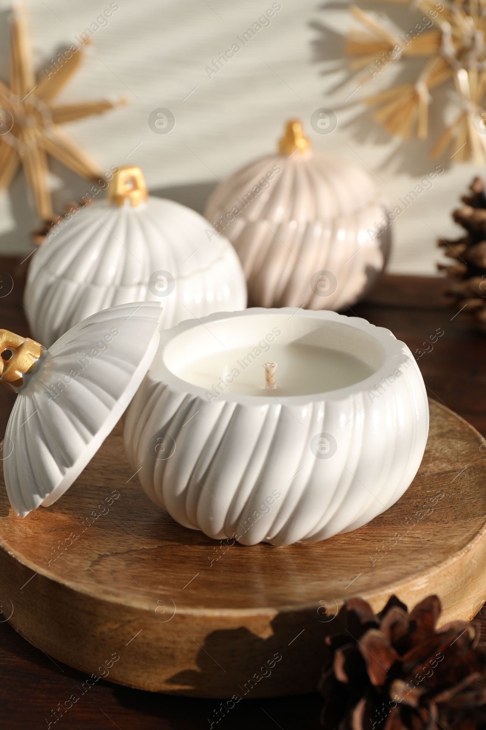 Photo of Soy wax candles and cones on wooden table. Beautiful christmas decor