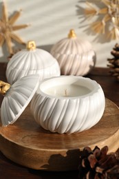 Photo of Soy wax candles and cones on wooden table. Beautiful christmas decor