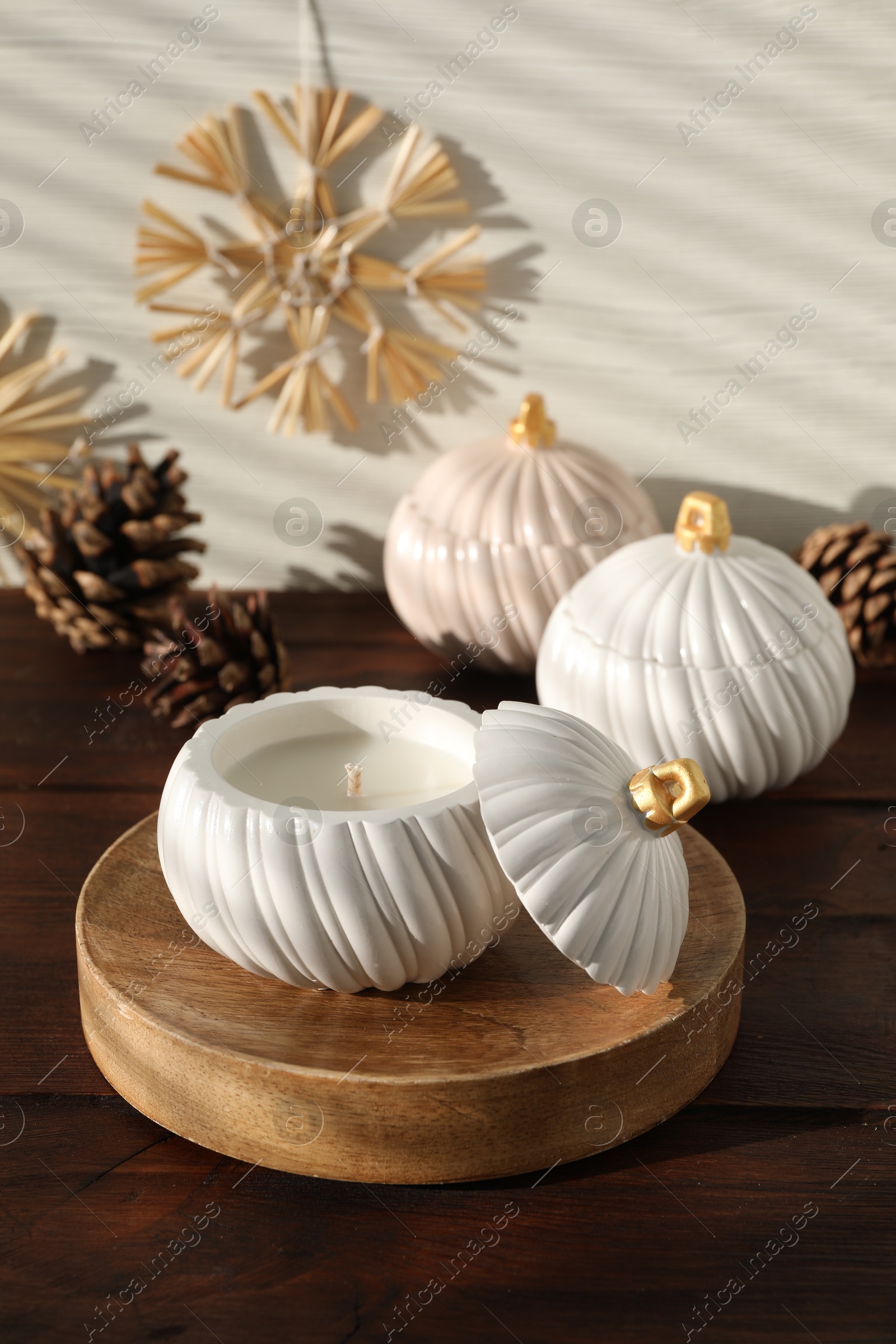 Photo of Soy wax candles and cones on wooden table. Beautiful christmas decor