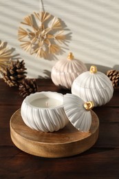 Photo of Soy wax candles and cones on wooden table. Beautiful christmas decor