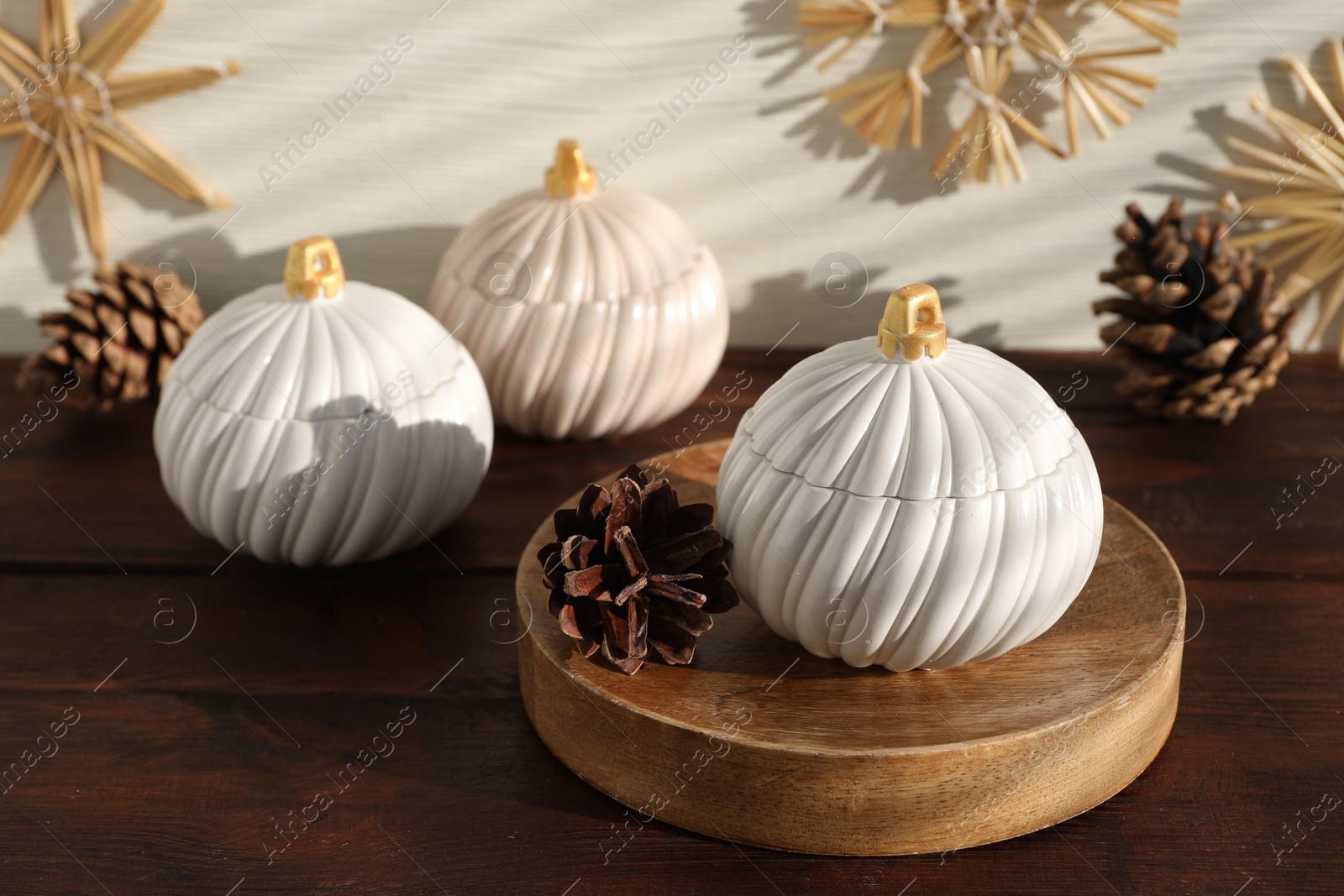 Photo of Soy wax candles and cones on wooden table. Beautiful christmas decor