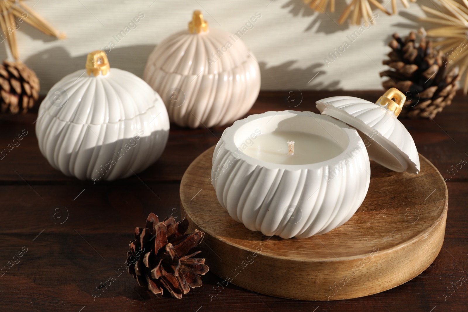 Photo of Soy wax candles and cones on wooden table. Beautiful christmas decor