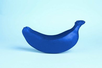 Image of One blue banana on light blue background