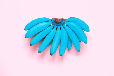 Image of Light blue bananas on pink background, top view