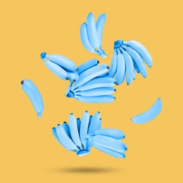 Image of Light blue bananas in air on pale orange background