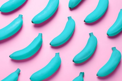 Image of Light blue bananas on pink background, top view