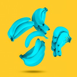 Image of Light blue bananas in air on yellow background