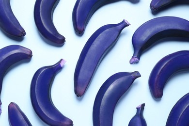 Dark blue bananas on light background, top view