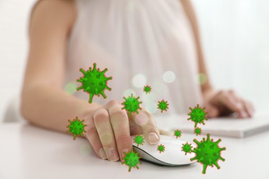 Image of Woman using computer mouse at table, closeup. Pathogens transmission, illustration of microbes