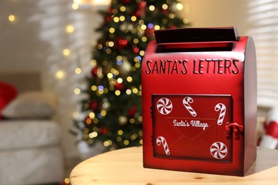 Photo of Santa Claus mailbox on wooden table indoors, space for text. Christmas atmosphere