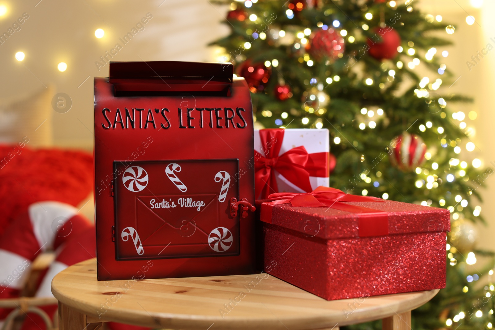 Photo of Santa Claus mailbox and gift boxes on wooden table indoors. Christmas atmosphere