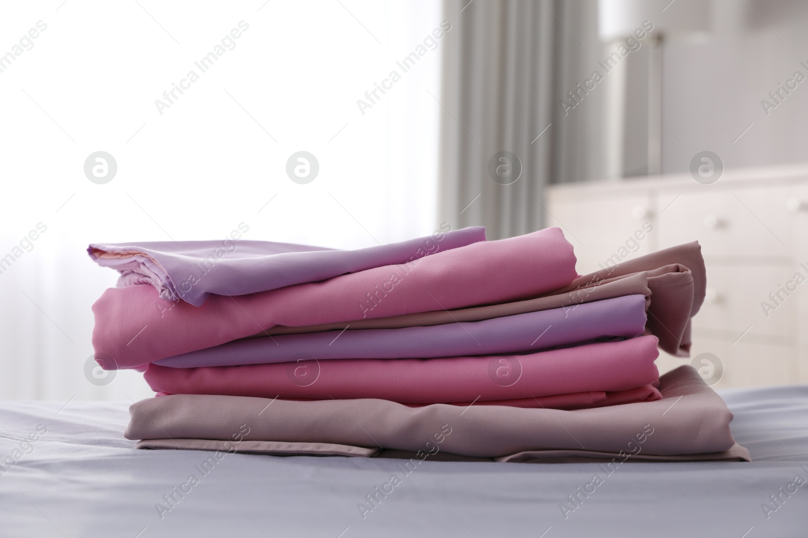 Photo of Clean color folded linens on bed indoors