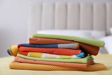 Photo of Clean color folded linens on bed indoors