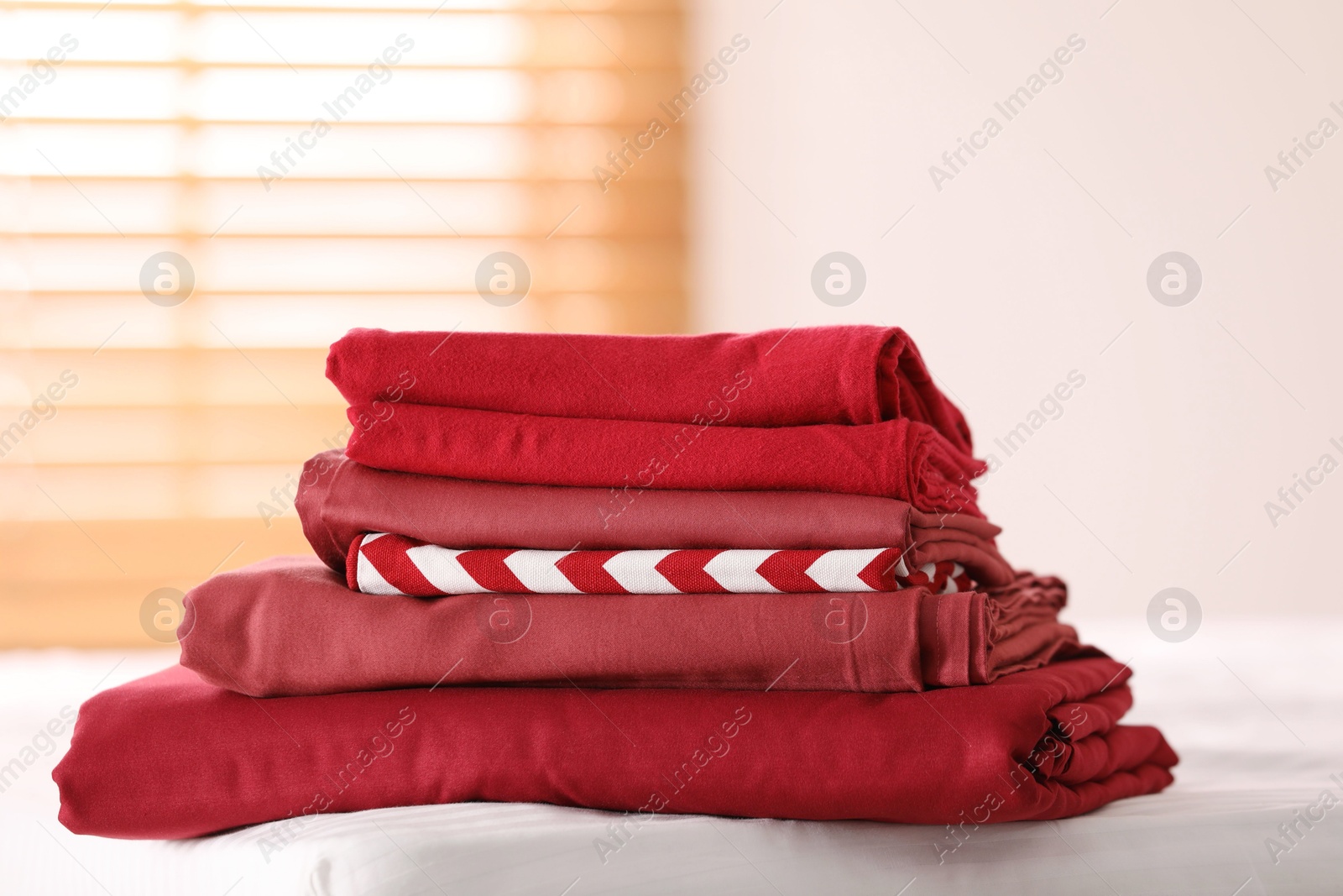 Photo of Clean color folded linens on bed indoors