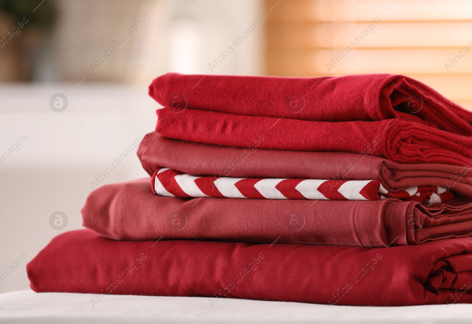 Photo of Clean color folded linens on bed indoors