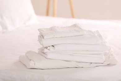 Photo of New clean folded linens on bed indoors