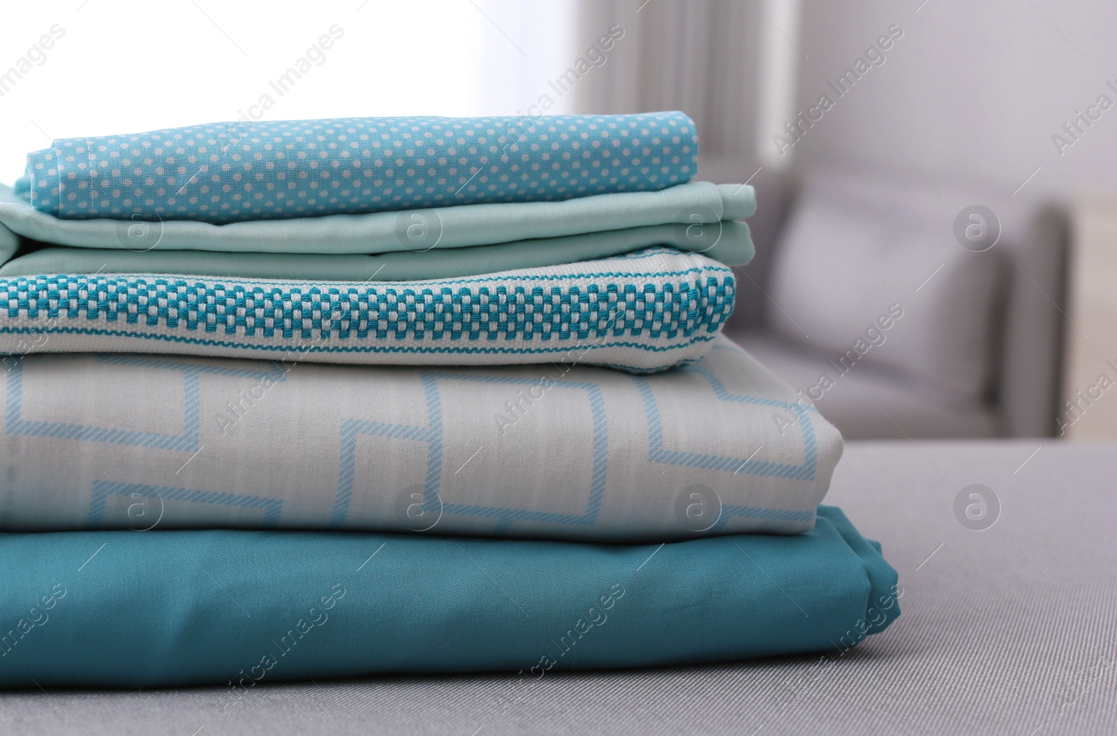 Photo of Stack of clean bed linens on table in room