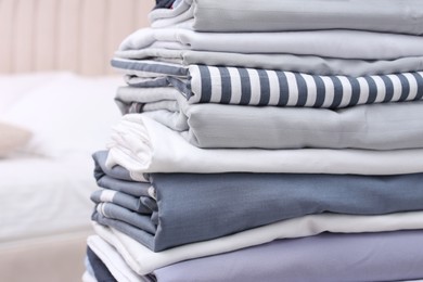 Stack of clean bed linens in bedroom, closeup. Space for text