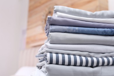 Photo of Stack of clean linens in bedroom, closeup