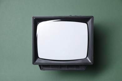 Photo of Retro tv set on green background, top view