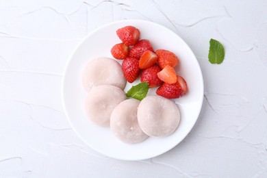 Photo of Delicious mochi and strawberries on white table, top view