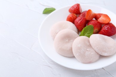 Photo of Delicious mochi and strawberries on white table, closeup