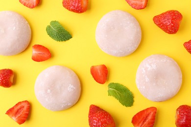 Photo of Delicious mochi and strawberries on yellow background, flat lay