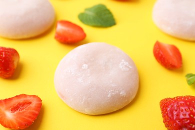 Photo of Delicious mochi and strawberries on yellow background, closeup