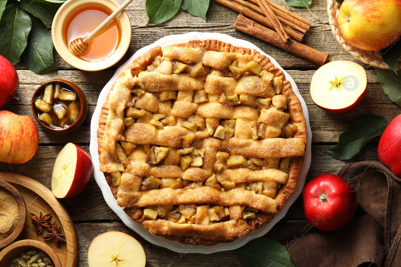 Photo of Homemade apple pie and ingredients on wooden table, flat lay