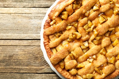 Photo of Homemade apple pie on wooden table, top view. Space for text