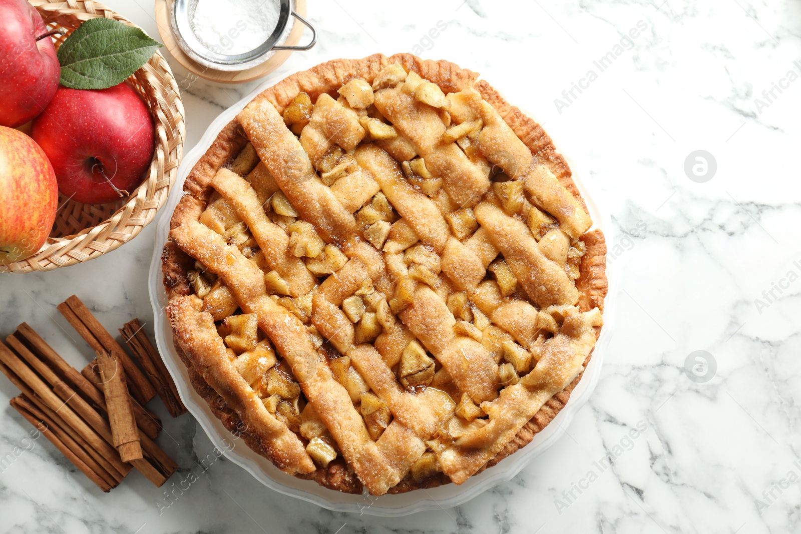 Photo of Homemade apple pie and ingredients on white marble table, flat lay