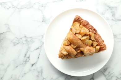 Photo of Slice of homemade apple pie on white marble table, top view. Space for text