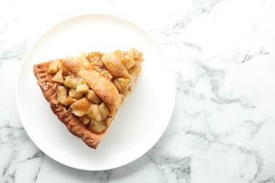 Photo of Slice of homemade apple pie on white marble table, top view. Space for text