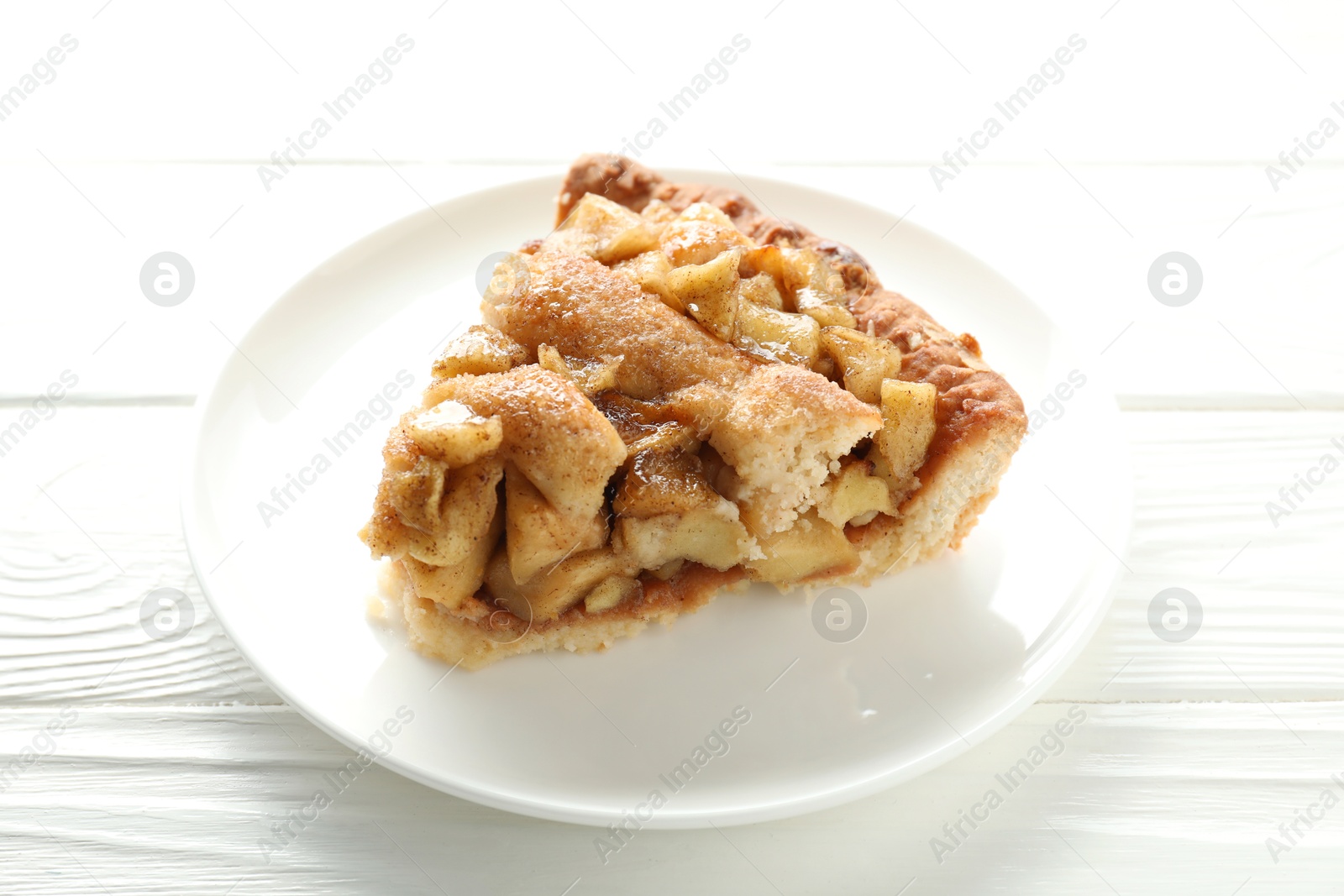 Photo of Slice of homemade apple pie on white wooden table