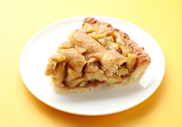 Photo of Slice of homemade apple pie on orange background, closeup