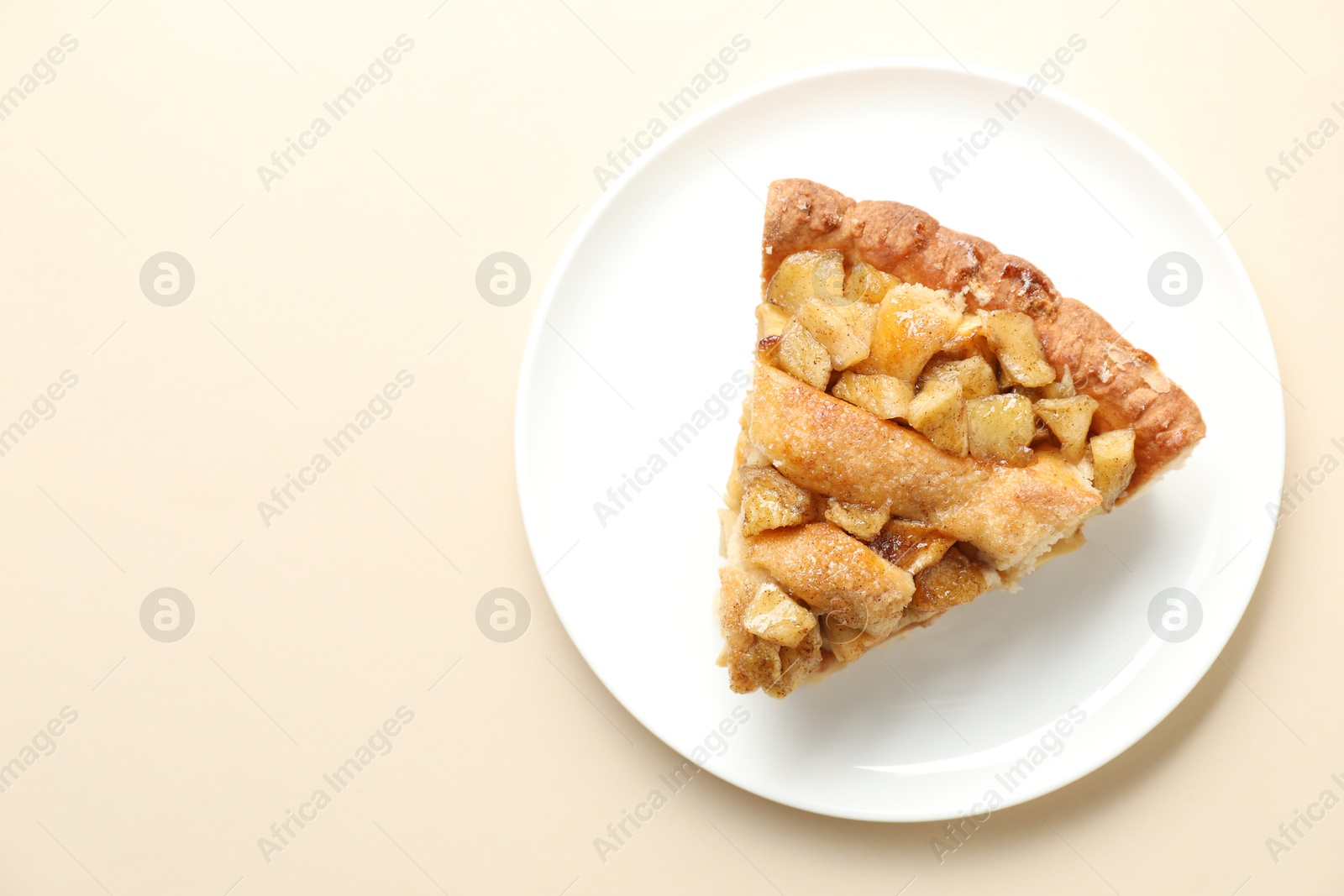 Photo of Slice of homemade apple pie on beige background, top view. Space for text