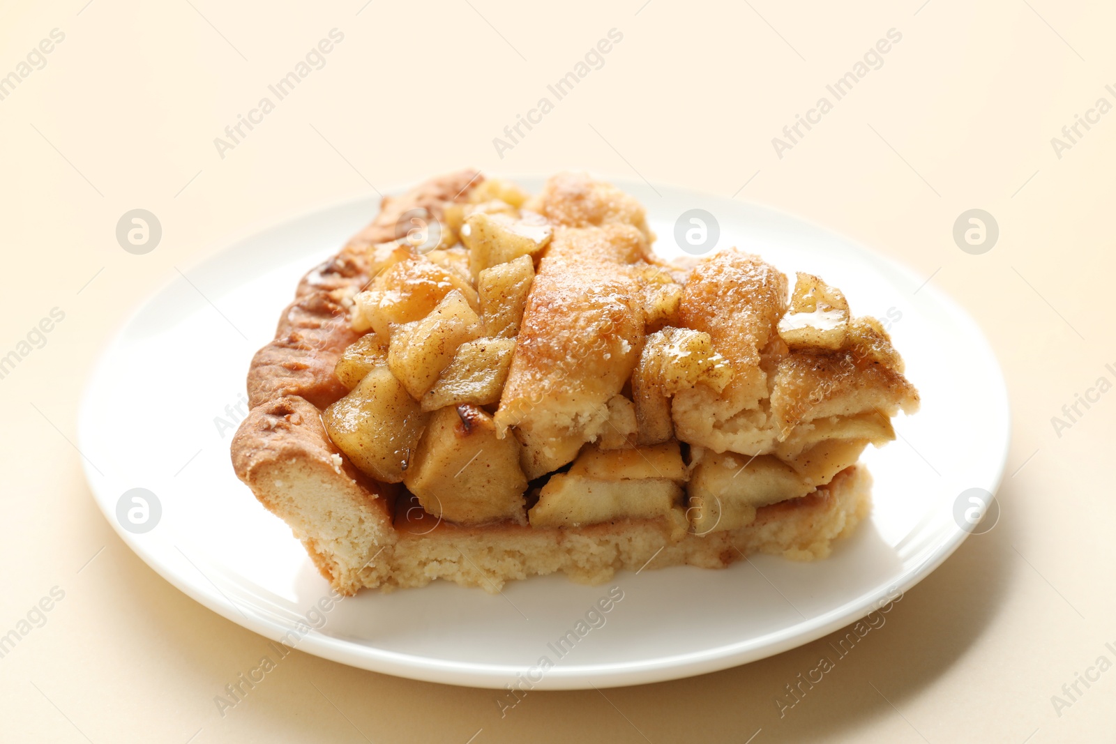 Photo of Slice of homemade apple pie on beige background, closeup