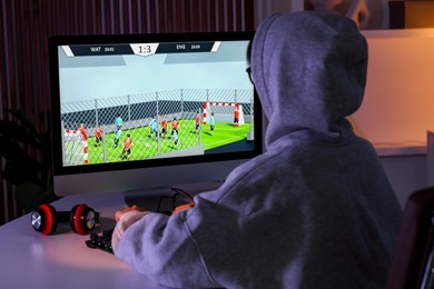 Photo of Woman playing video game with keyboard at table indoors, back view