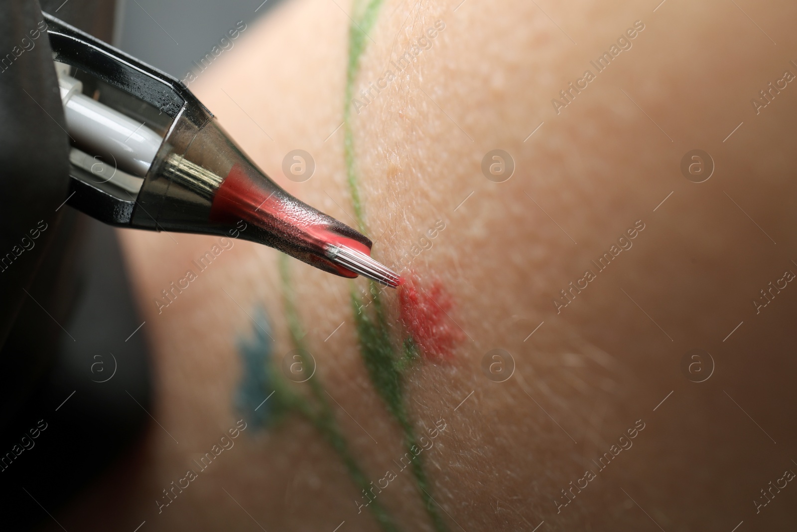 Photo of Woman making tattoo with machine, macro view