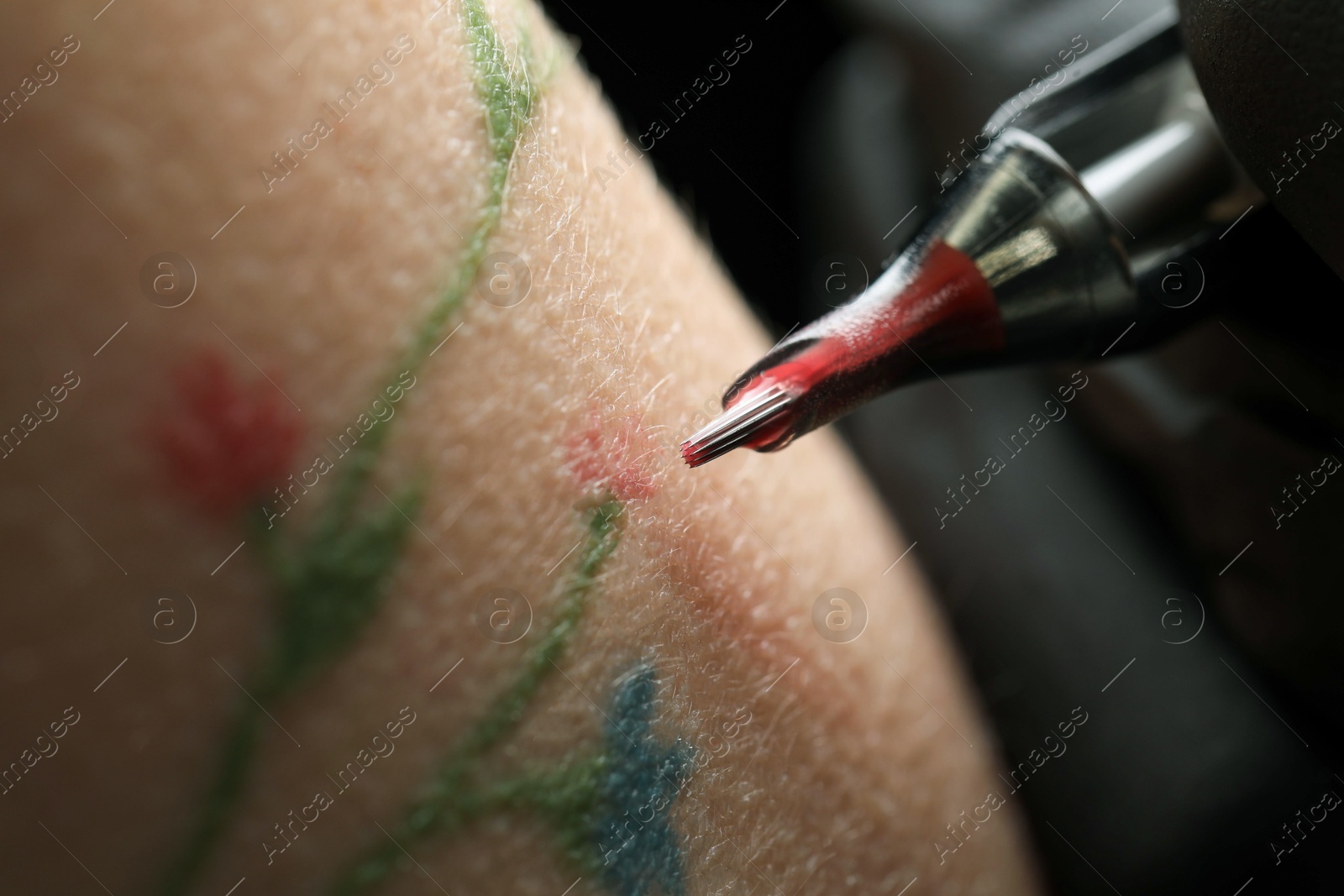 Photo of Woman making tattoo with machine, macro view